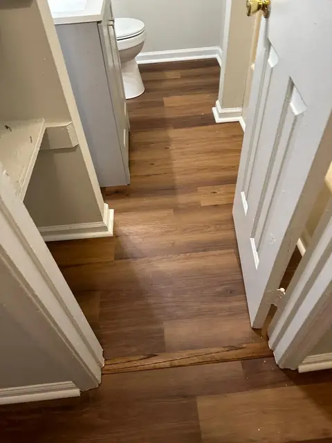 Wood-look plank flooring in a small bathroom and hallway