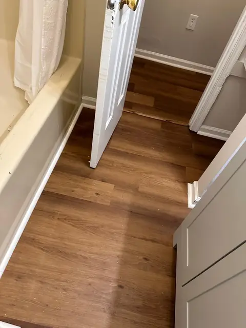 Wood-look plank flooring installed in a bathroom next to the tub