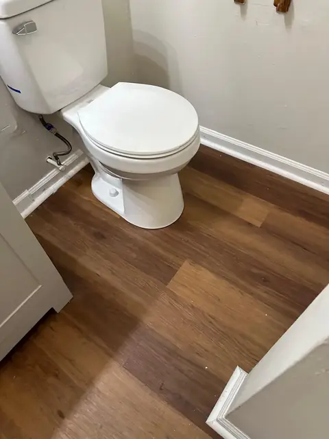 Wood-look plank flooring around the toilet in a remodeled bathroom