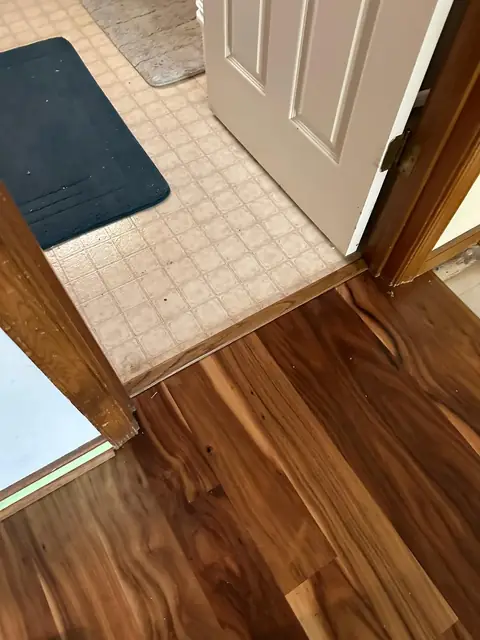 Wood flooring meeting the existing floor at a doorway