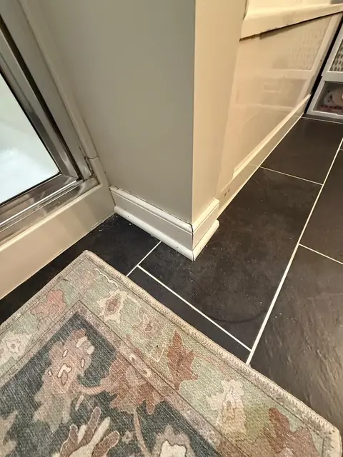 Large-format dark slate-look tile floor next to a shower