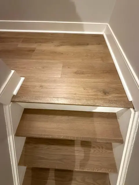 Staircase with wood-look treads and white risers seen from the top