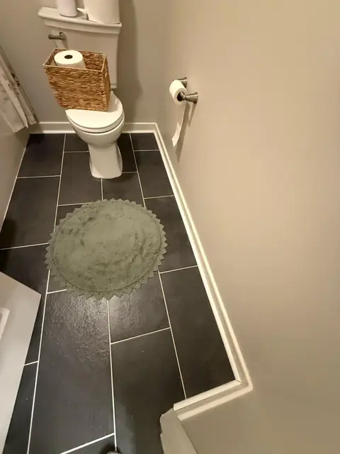 Half bathroom with large dark tile floor