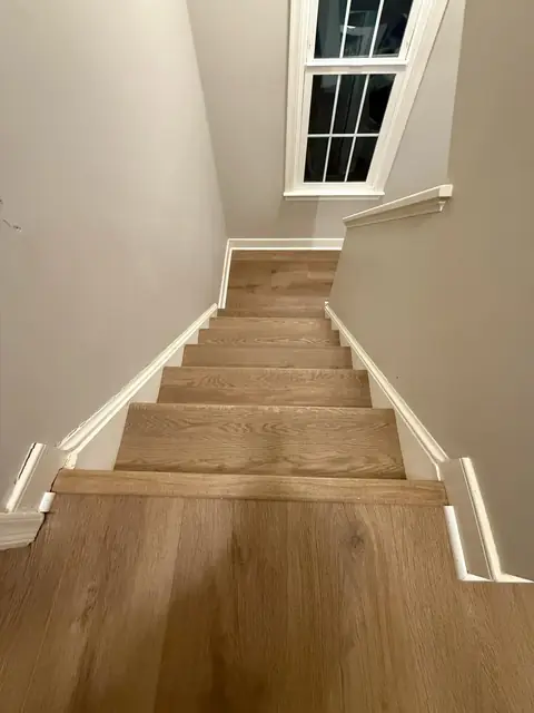 Staircase and landing with matching wood-look flooring