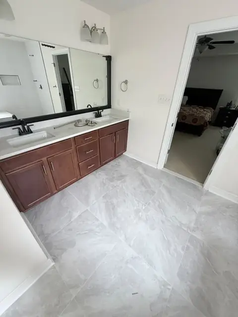 Double vanity area on a new large-format marble-look porcelain tile floor