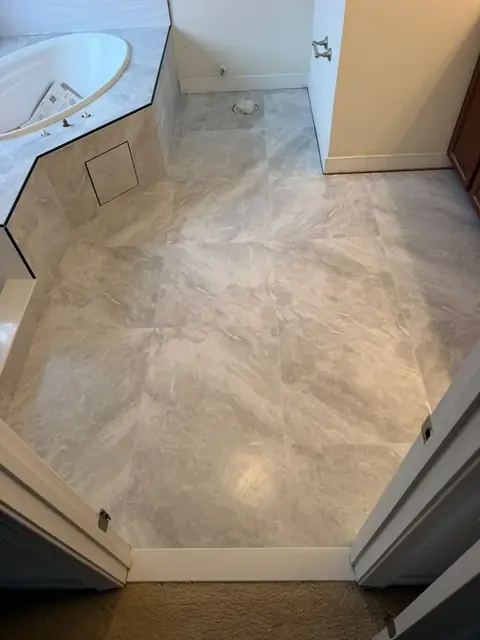 Large-format marble-look porcelain tile floor in a primary bathroom