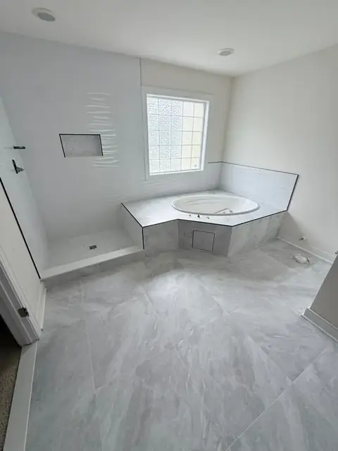 Primary bathroom with a walk-in shower, a tiled corner tub deck and a large-format marble-look porcelain floor